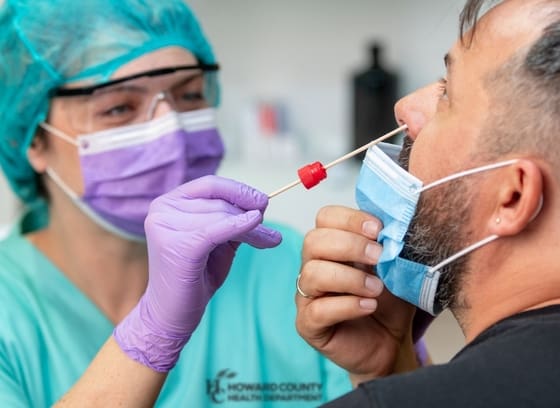 A doctor is putting on a mask for a patient.