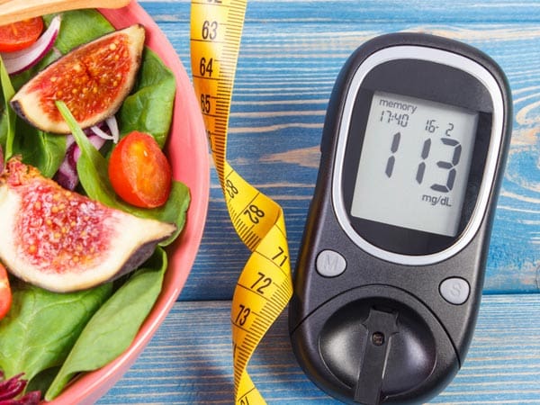 A bowl of salad and a blood glucose meter