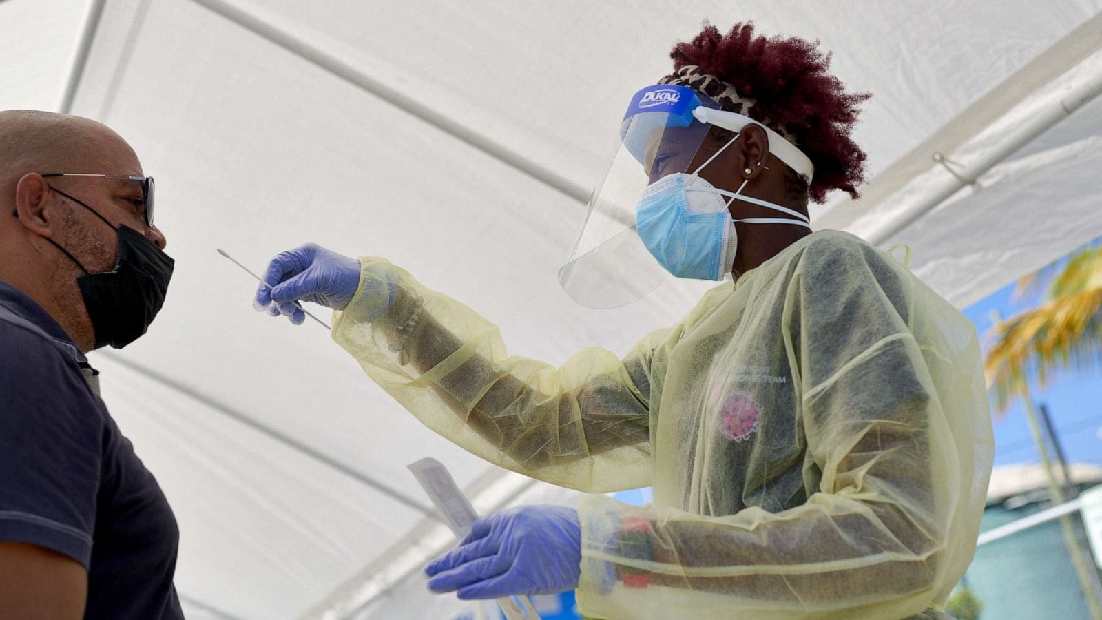A person in ppe and gloves wearing a mask.